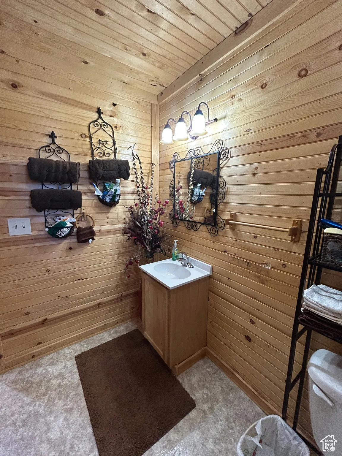 Bathroom with wooden walls, vanity, and wooden ceiling