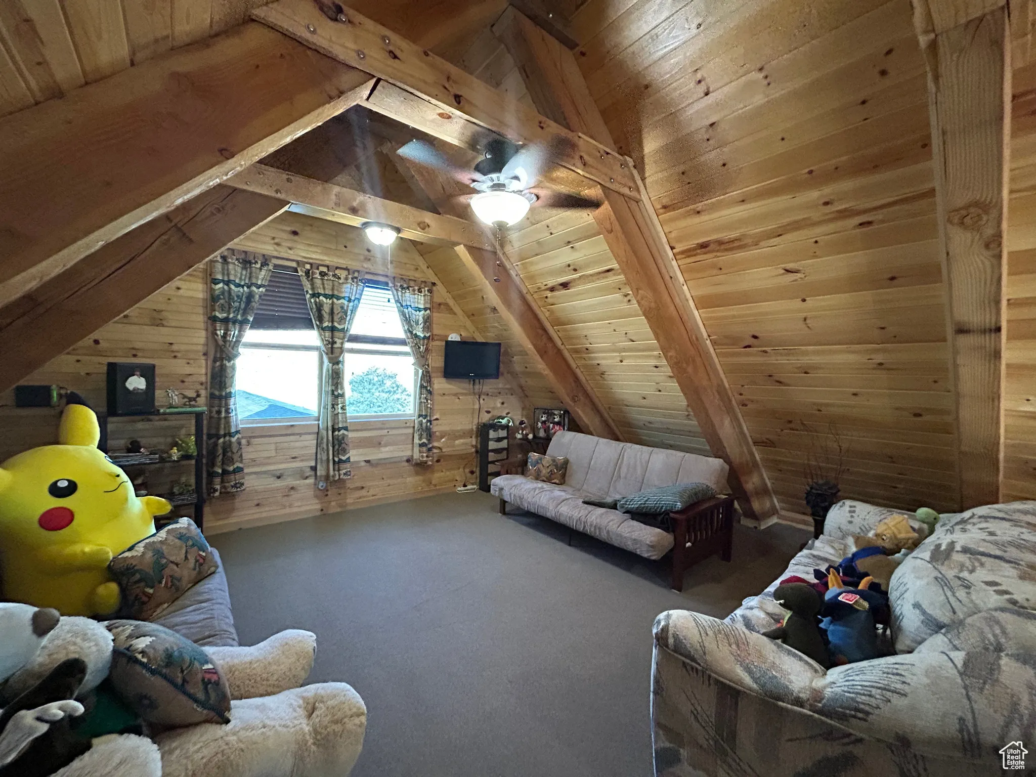 Bedroom featuring wooden walls, wood ceiling, lofted ceiling, carpet, and ceiling fan