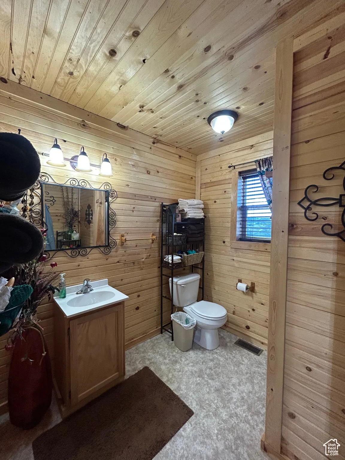 Bathroom with vanity, wood walls, and wooden ceiling