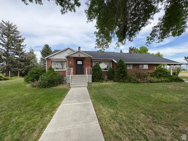 Ranch-style house with brick siding, a front yard, and a chimney