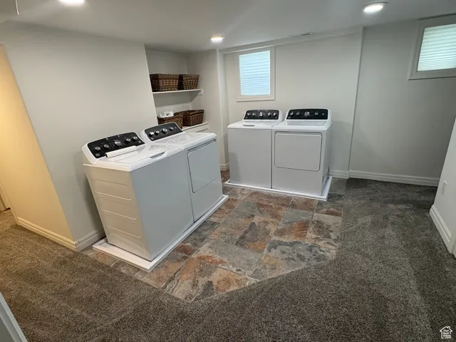 Laundry room with washer and dryer, dark stone finish flooring, dark colored carpet, and recessed lighting