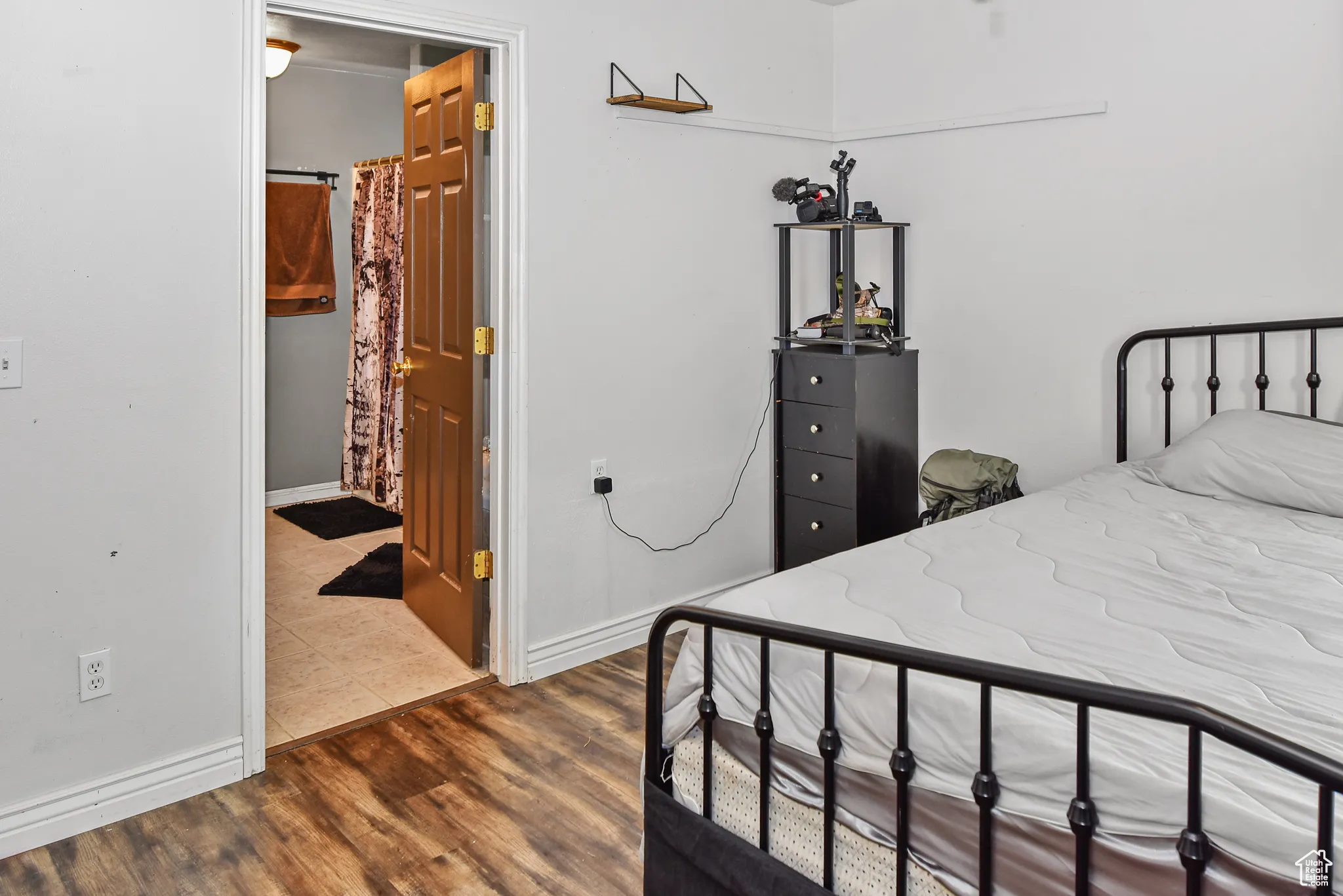 Bedroom featuring dark wood-style floors and connected bathroom