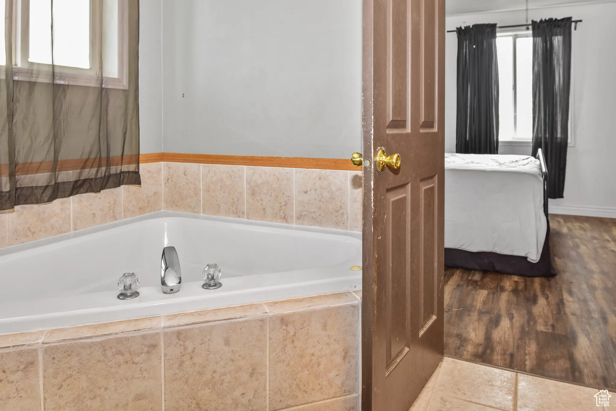 Ensuite bathroom featuring a bath and tile patterned flooring