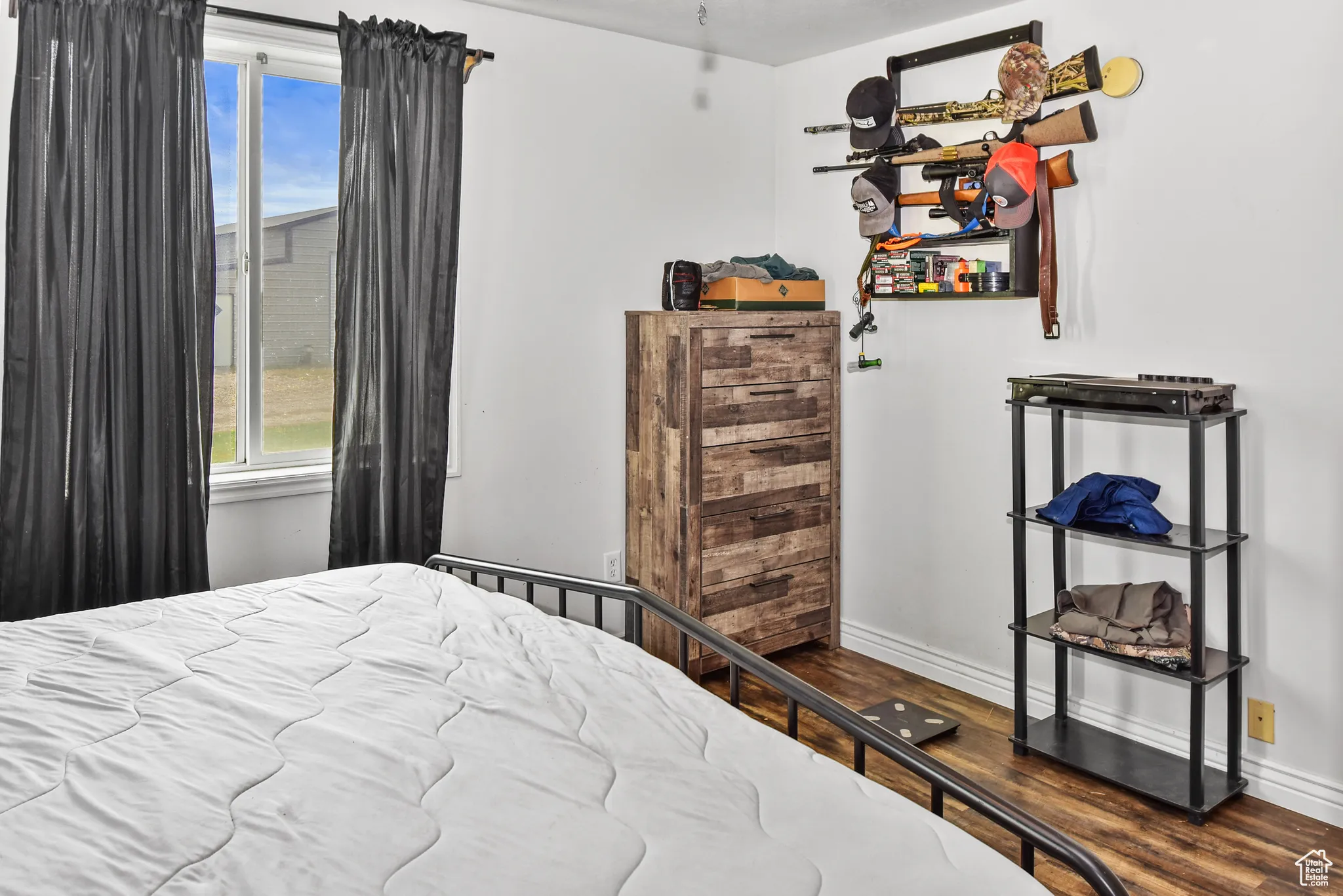 Bedroom with dark wood-style flooring and baseboards