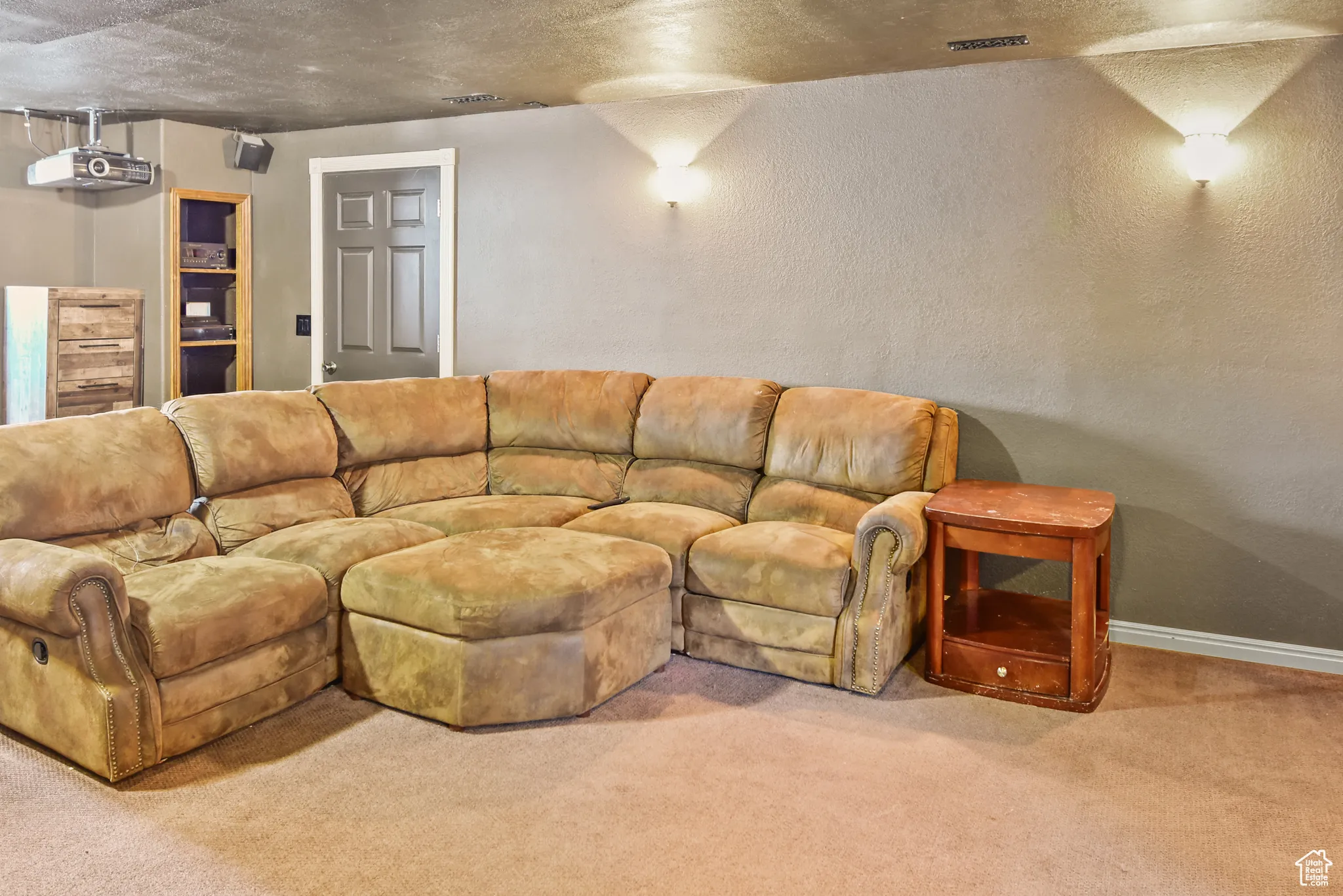 Carpeted living room with a textured wall and a textured ceiling