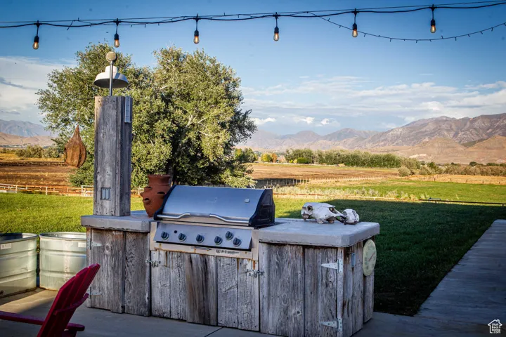 View of patio with a rural view, a mountain view, and an outdoor kitchen