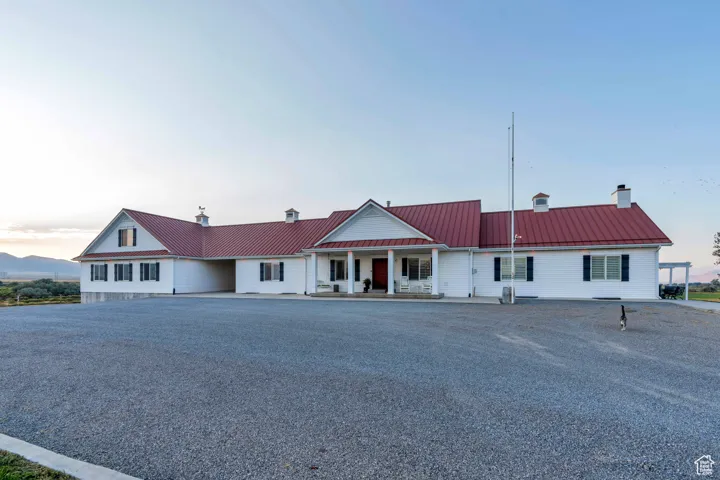 View of front of home featuring a chimney, a metal roof, a porch, and a standing seam roof