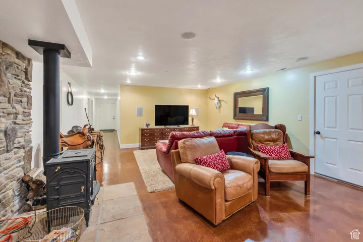 Living room featuring a wood stove, finished concrete floors, and a textured ceiling