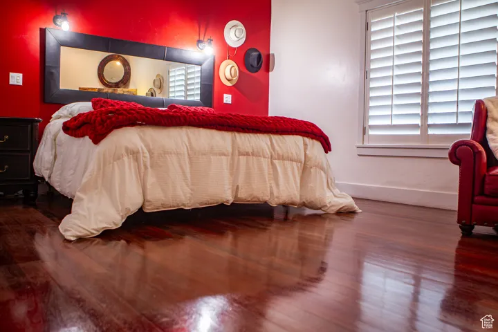 Bedroom with multiple windows and wood finished floors