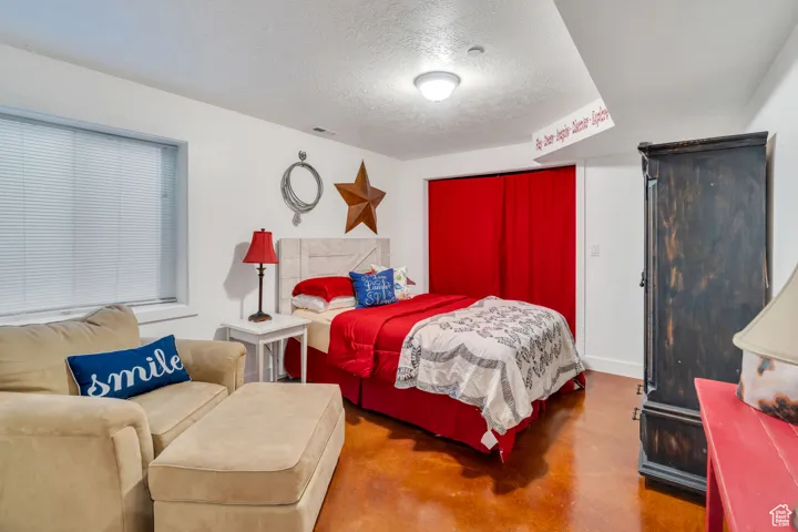 Bedroom featuring a textured ceiling and concrete floors