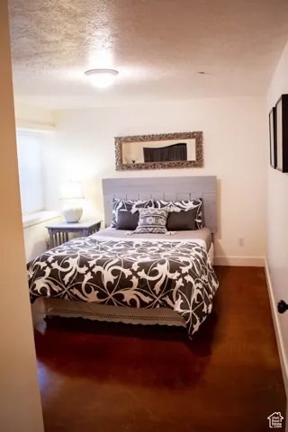 Bedroom featuring a textured ceiling and baseboards