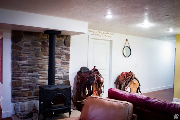 Living area featuring a textured ceiling and a wood stove