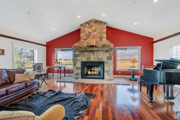 Living room with hardwood / wood-style floors, a fireplace, and lofted ceiling