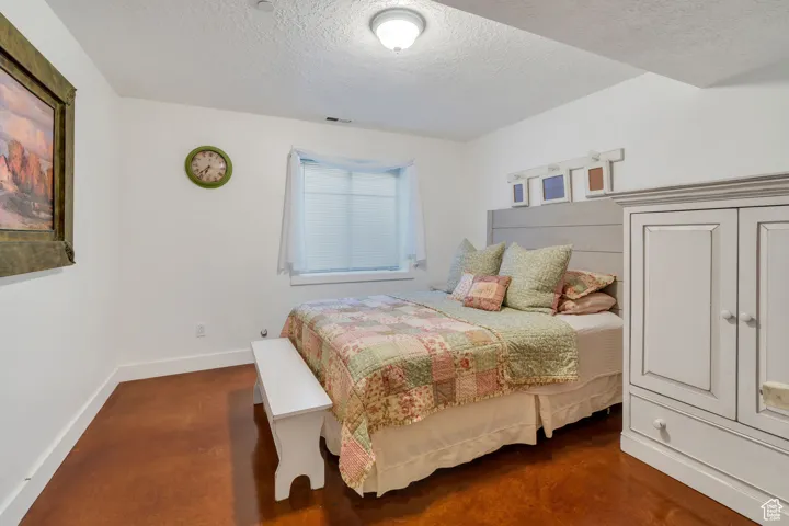 Bedroom with a textured ceiling and baseboards
