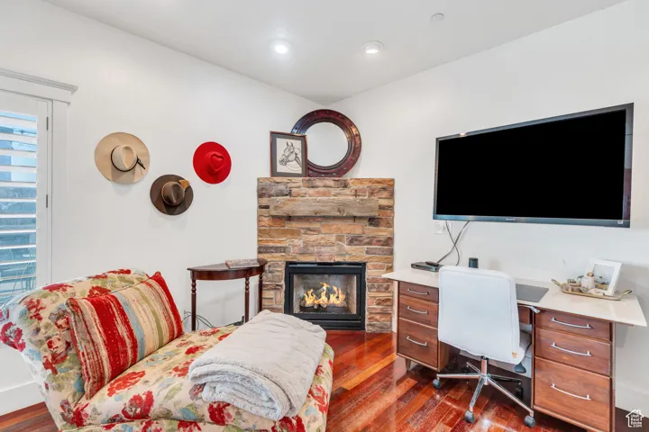Office space featuring a fireplace, dark wood-type flooring, and recessed lighting