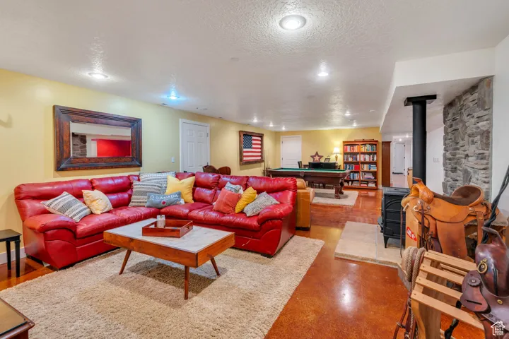 Living area featuring a wood stove, billiards table, a textured ceiling, and recessed lighting