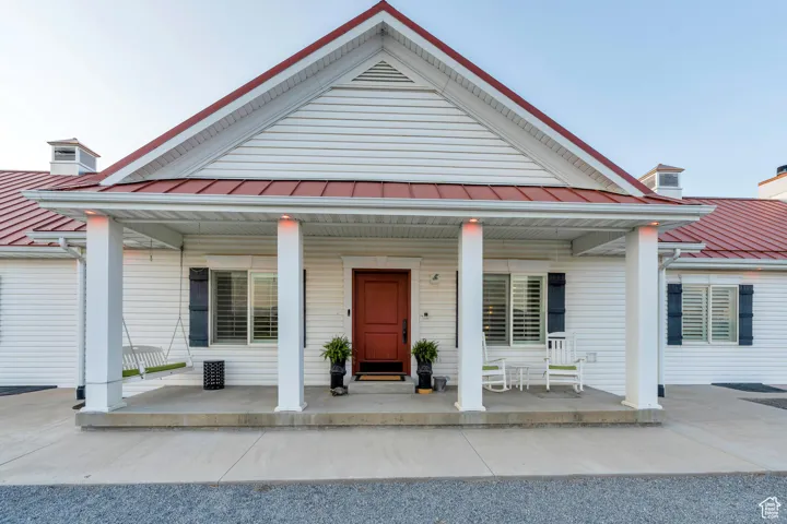 View of front facade featuring covered porch, a standing seam roof, and a metal roof
