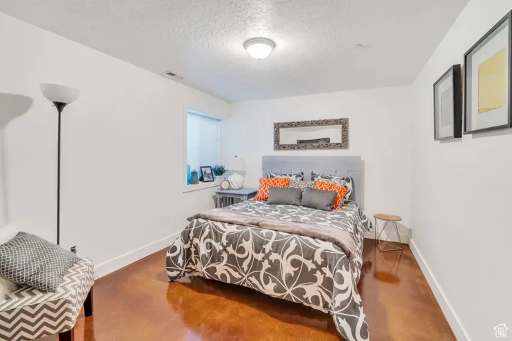 Bedroom featuring a textured ceiling and finished concrete floors