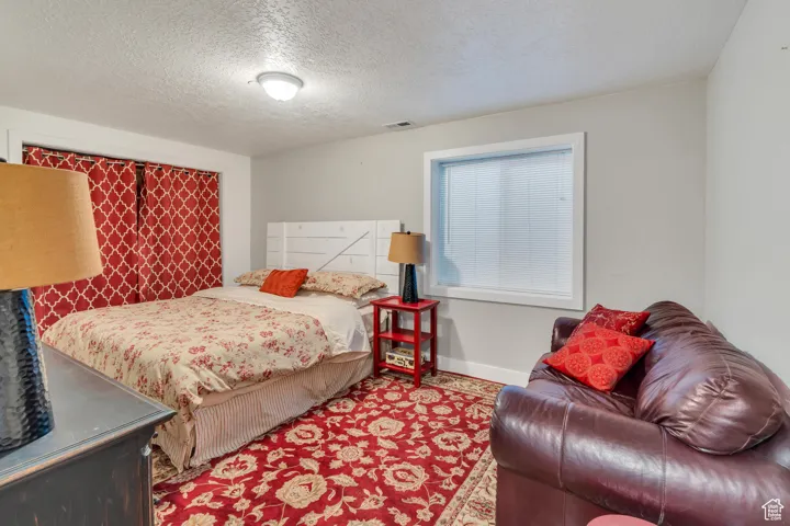 Bedroom featuring a textured ceiling and baseboards