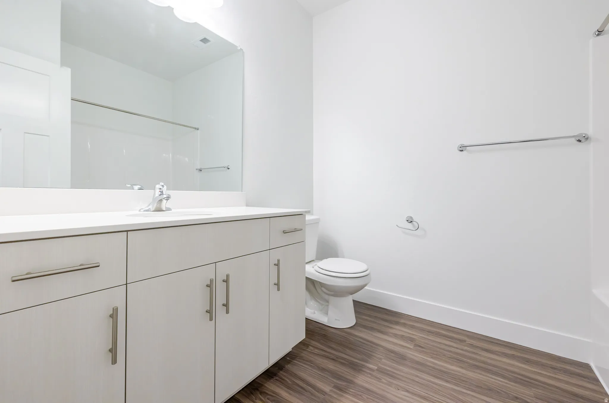 Bathroom featuring vanity, dark wood-style flooring, and a shower