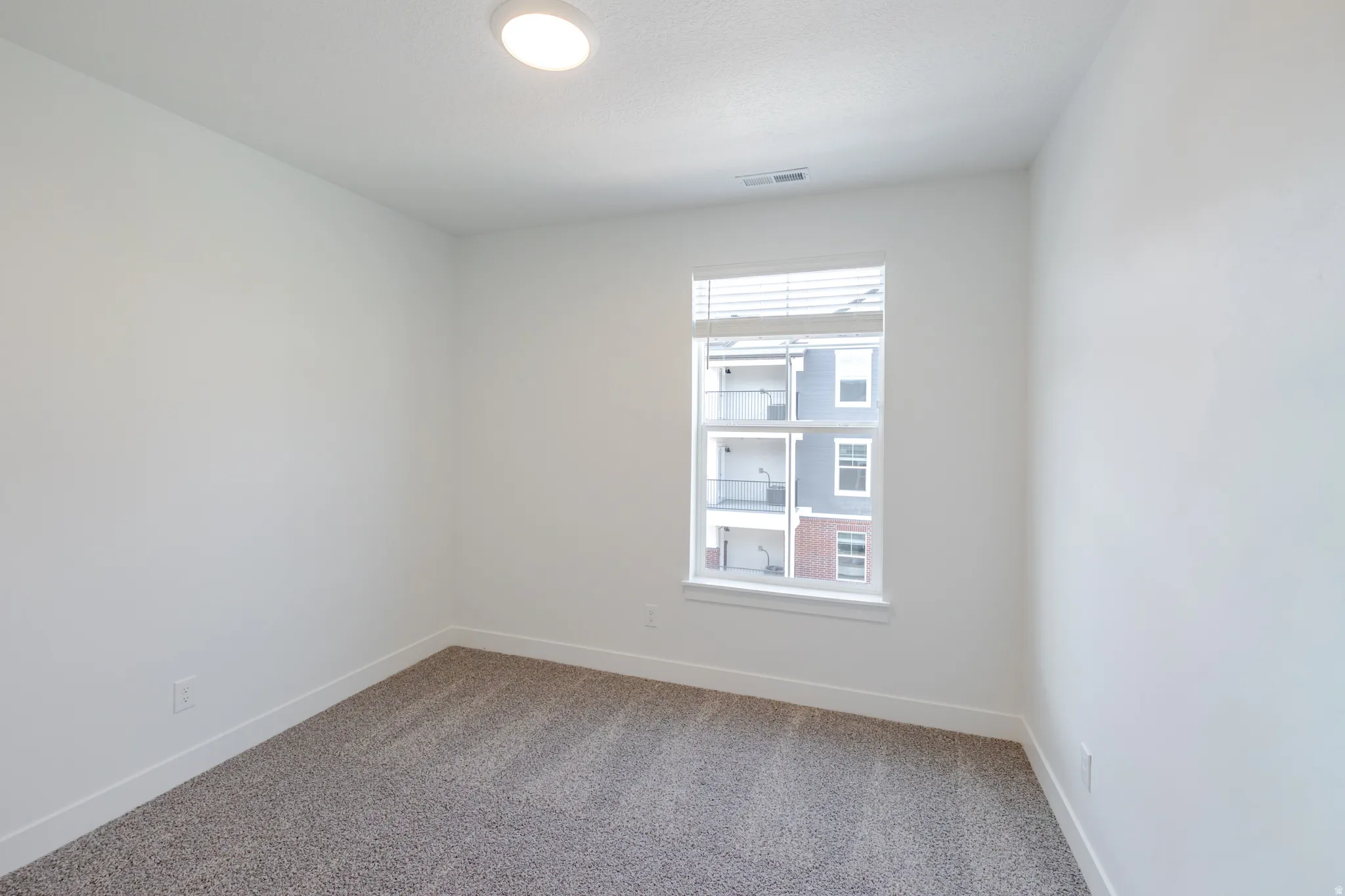 Carpeted spare room with baseboards