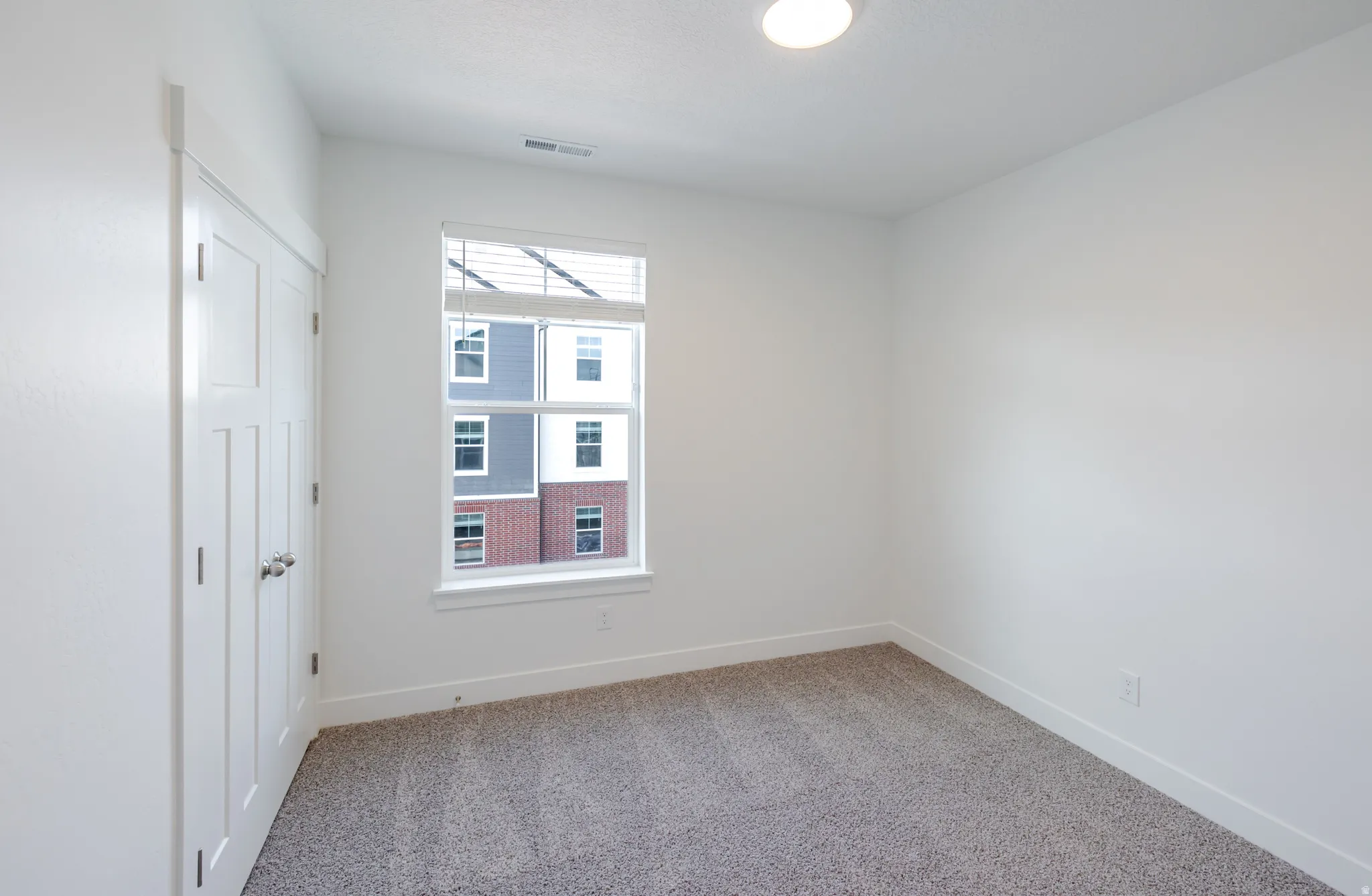 Empty room featuring baseboards and light carpet