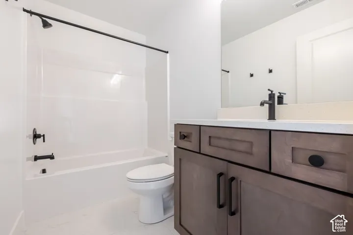 White bathtub with matte black fixtures, white toilet, single vanity with wood-finish cabinetry, light-colored countertop, and a wall-mounted mirror