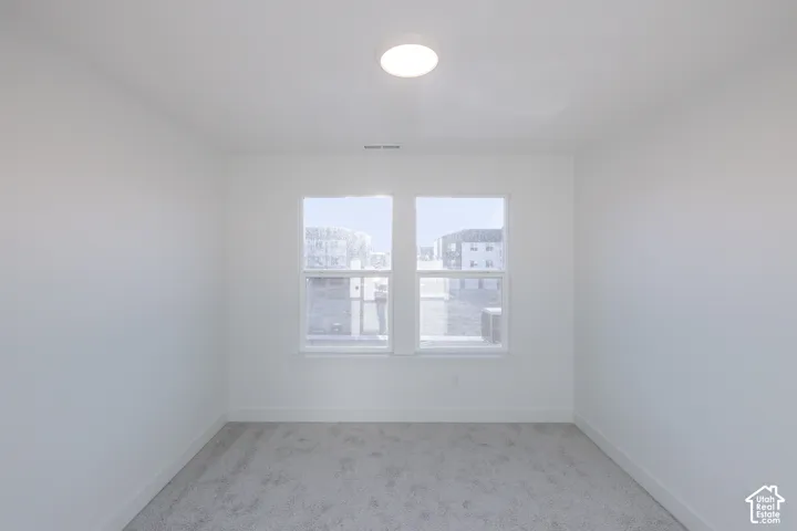 Recessed ceiling lighting, white walls, and gray carpeting