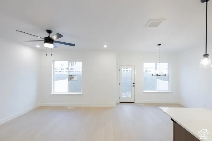 Wood-finish flooring, recessed lighting, and a contemporary ceiling fan