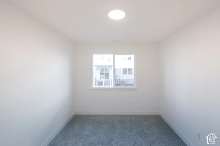 Recessed window with white trim, gray carpet flooring, and a flush-mount ceiling light fixture