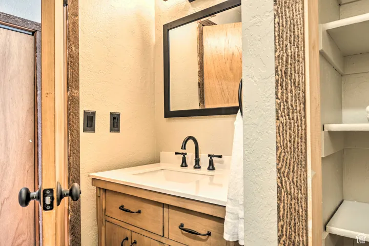 Bathroom featuring a textured wall and vanity