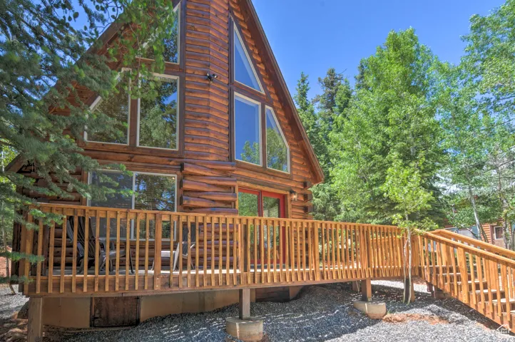 Rear view of property featuring a wooden deck and log siding