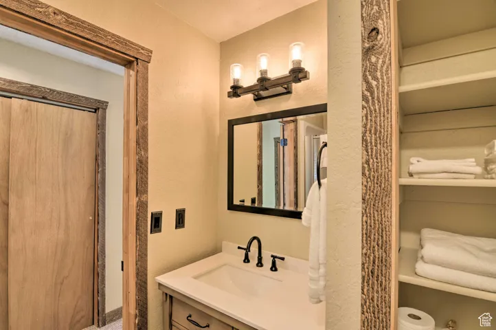Bathroom featuring a textured wall and vanity