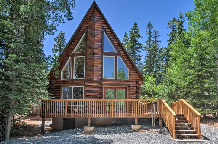 Rear view of property featuring log siding, a deck, and stairs