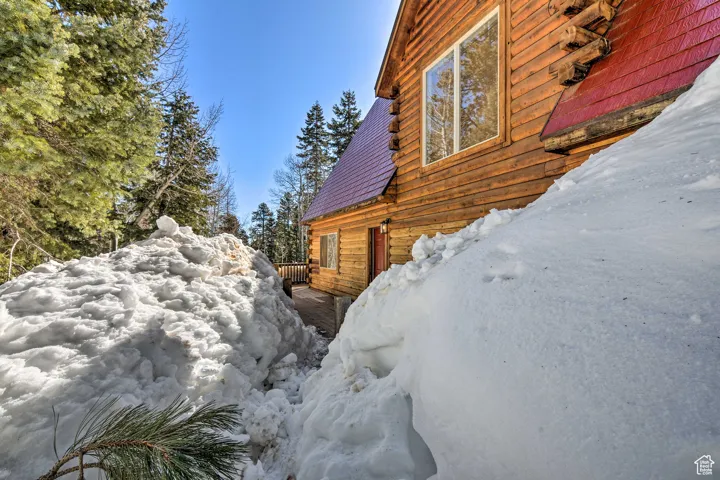 View of snow covered exterior featuring a wooden deck