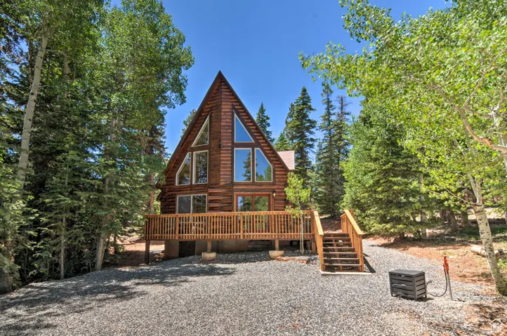 Back of house with a deck and log siding