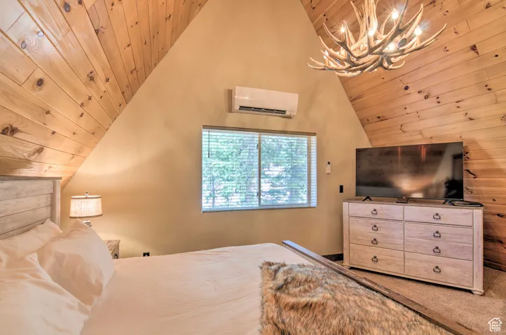 Bedroom with wood ceiling, lofted ceiling, a wall mounted AC, a chandelier, and wooden walls