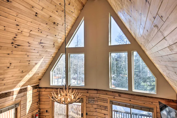 Detailed view of wood ceiling, a chandelier, and wood walls