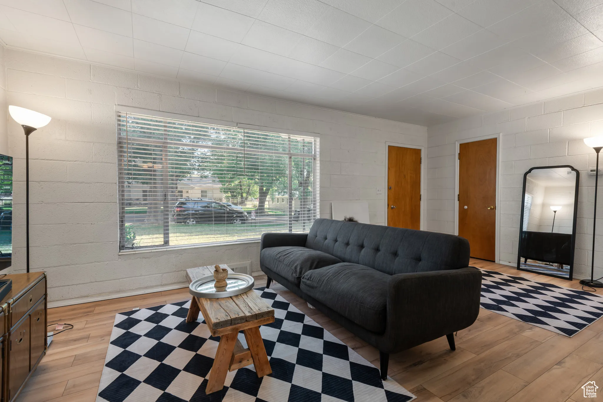 Living area with wood-type flooring and concrete block wall