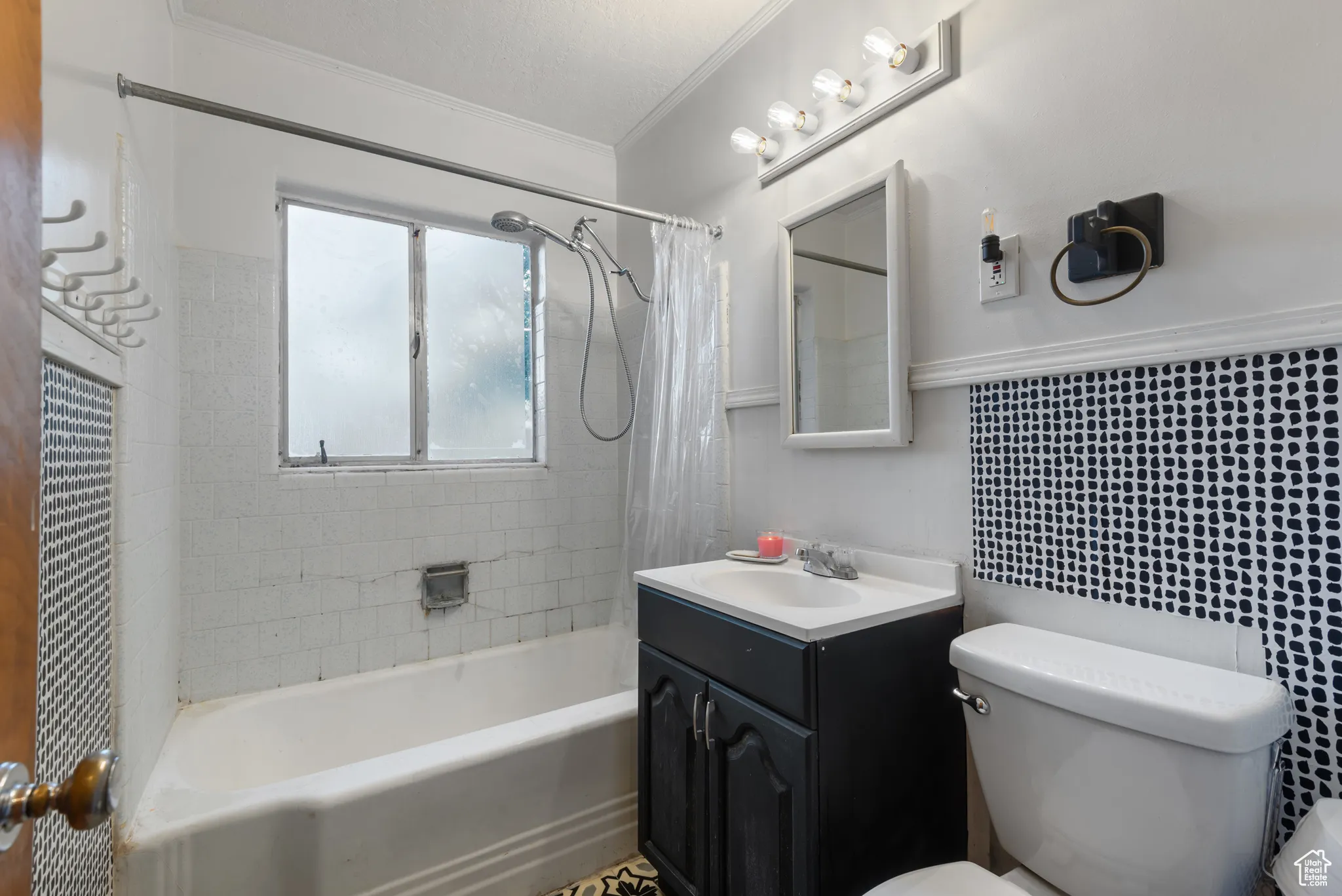 Bathroom featuring shower / bath combination with curtain, vanity, crown molding, and tasteful backsplash