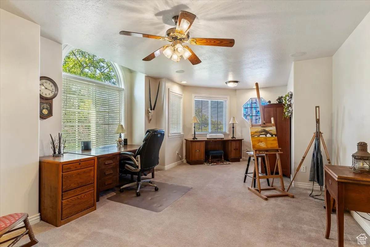 Office featuring light carpet, ceiling fan, and a textured ceiling