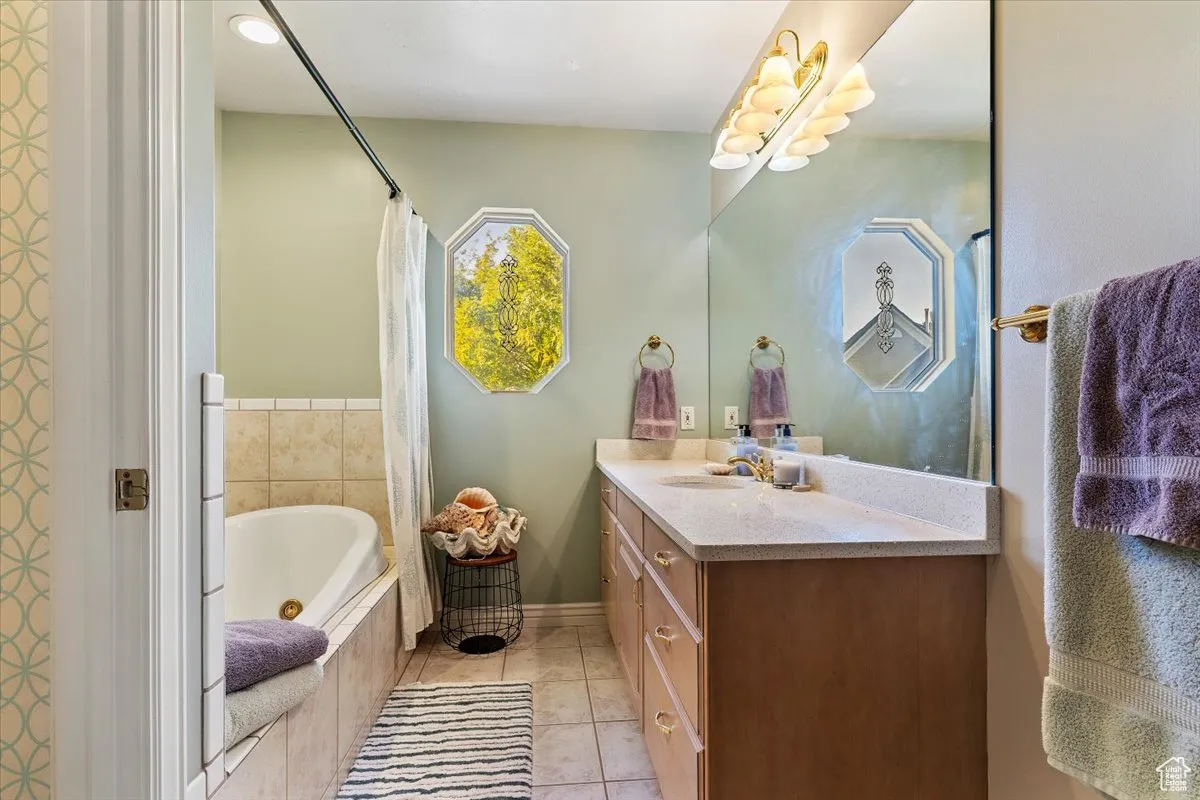 Bathroom featuring vanity, a whirlpool tub, and light tile patterned floors