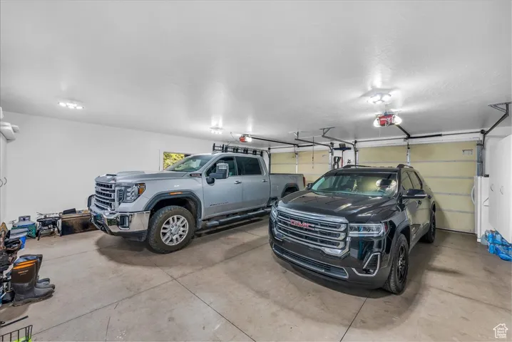 Garage with white refrigerator and a garage door opener