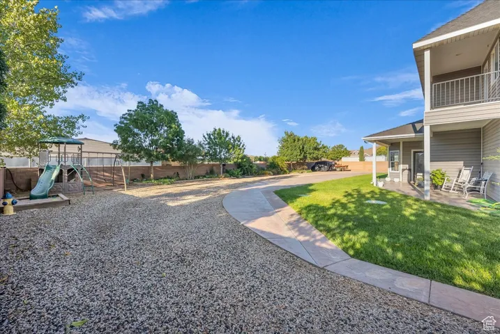 View of yard featuring a playground and a balcony