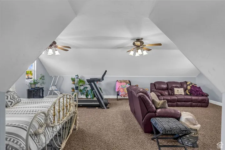 Bedroom with carpet floors and lofted ceiling