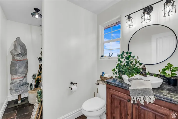 Half bathroom featuring vanity and toilet