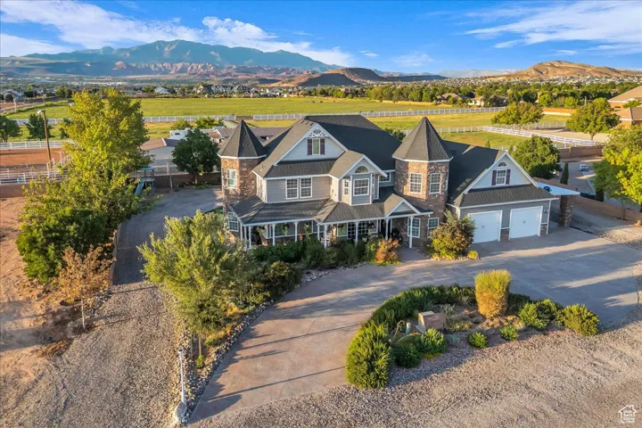 View of front of home with driveway, a mountain view, and stone siding