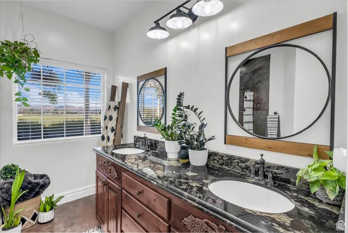Bathroom with double vanity and concrete flooring