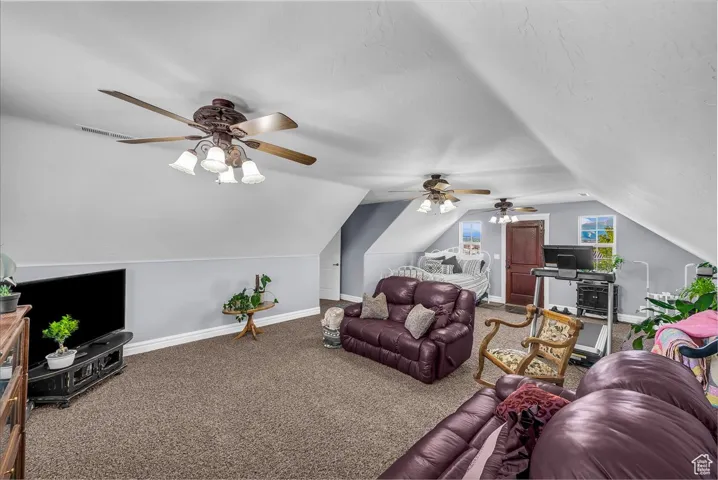 Living room featuring carpet and lofted ceiling