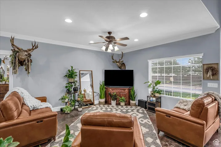 Living room featuring ornamental molding, a ceiling fan, and recessed lighting